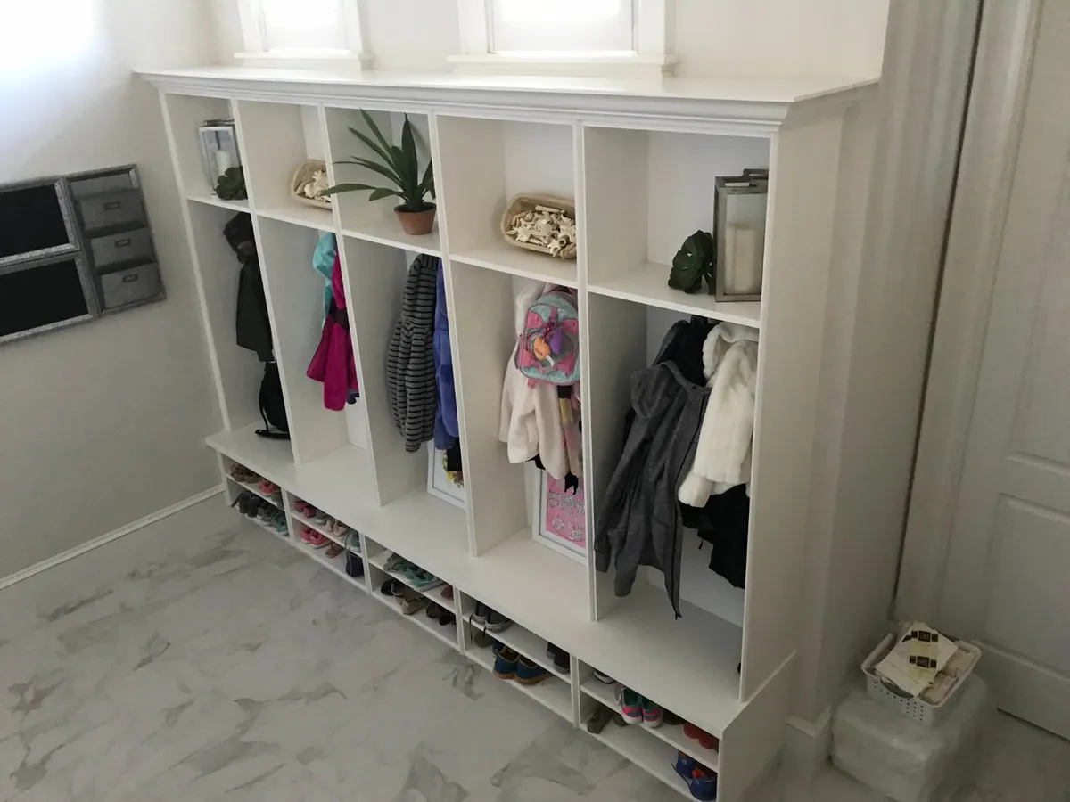 A custom mudroom with personal lockers, bench seating and coat hooks