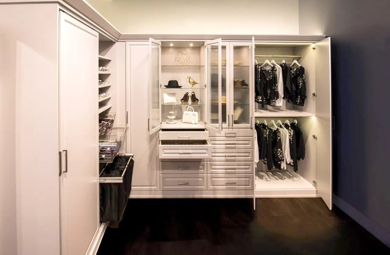 A custom-organized SpaceCraft walk-in closet with wood shelving and LED lighting